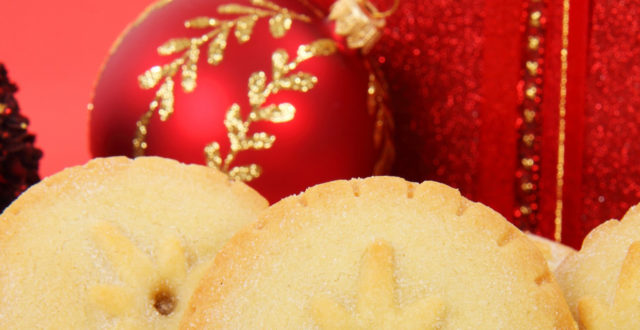 Jouluinen kuva makeista piirakoista ja joulukoristeista.