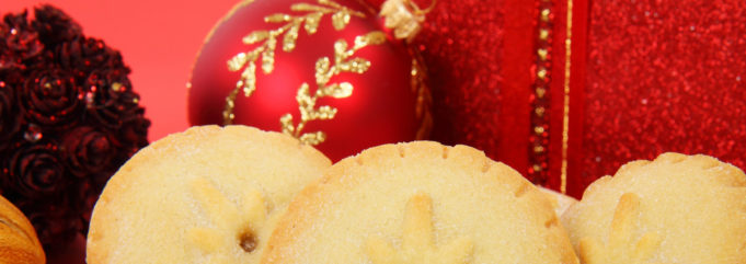 Jouluinen kuva makeista piirakoista ja joulukoristeista.