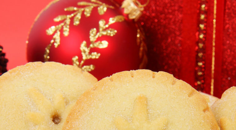 Jouluinen kuva makeista piirakoista ja joulukoristeista.