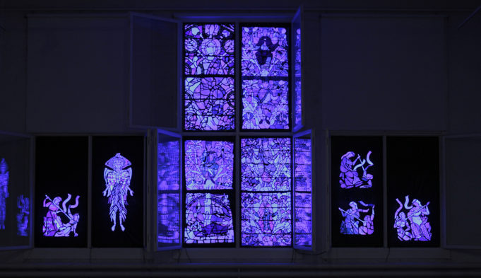Valotaideteos, joka esittää keskiaikaisia lasimaalauksia sinisessä valossa
