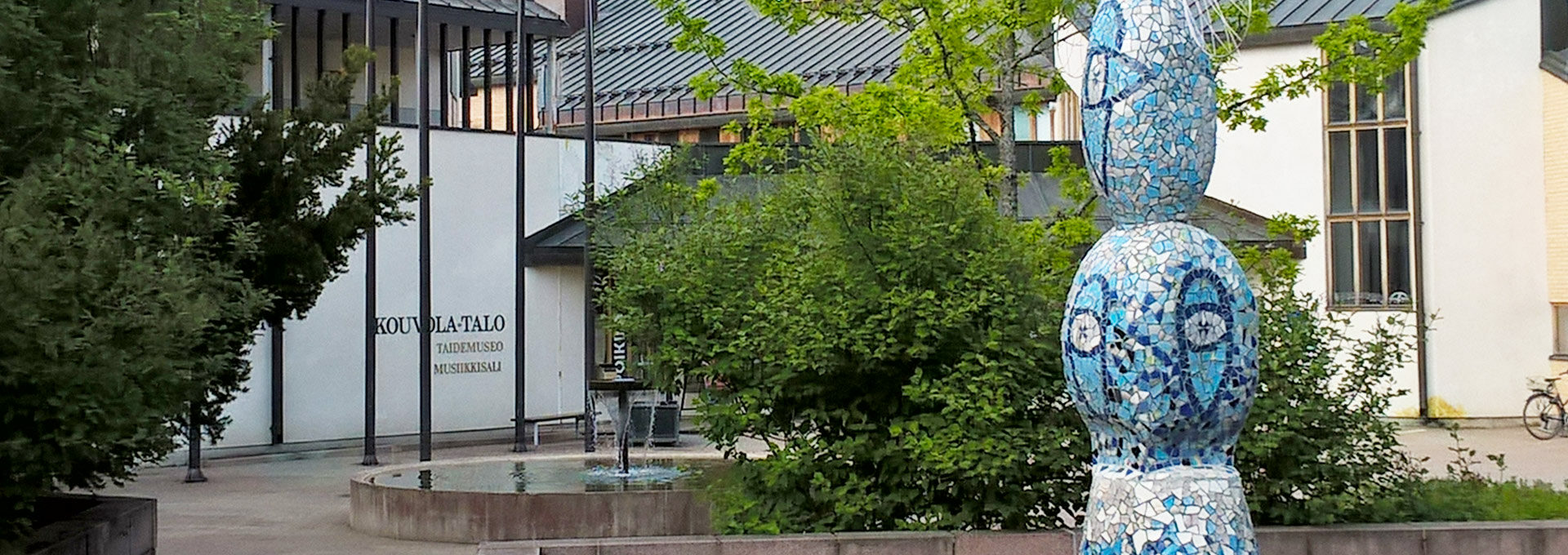 Kouvolatalon sisäänkäynti ja etupihan sininen mosaiikkipatsas.